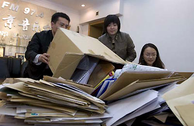 Staff members sort out envelopes filled with entries for the Beijing Olympics theme song in Beijing, March 10, 2008. Monday was the deadline for entries. 