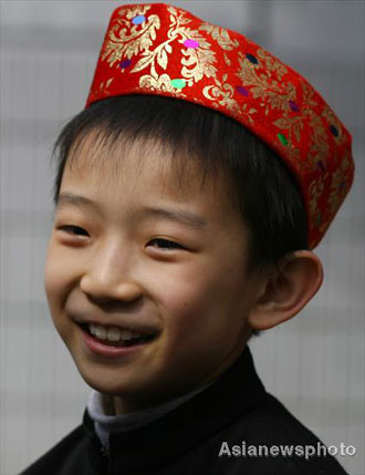 Tang Haiwen, a boy of the Hui ethnic group, smiles as he plays with other pupils at Lanzhou Qing Hua Primary School, in Lanzhou, capital of Northwest China's Gansu Province, March 15, 2008. The Beijing Organizing Committee for the Olympic Games (BOCOG) recently invited the school, which is known for having students from many ethnic groups, to submit photographs of smiling children for possible use in the August 8 Opening Ceremony of the Beijing Olympic Games. BOCOG started collecting photographs of children's smiling faces from around the world on Sept 4 last year. [Asianewsphoto] 