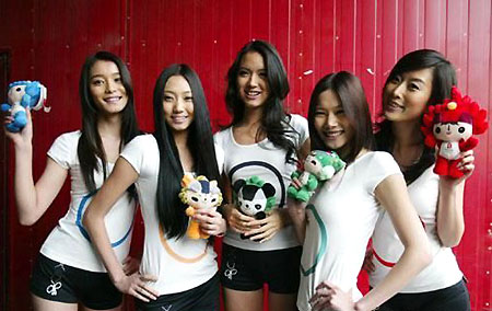 Zhang Zilin (C), who was crowned Miss World 2007, poses with four other models with each holding a Fuwa, the mascots for Beijing Olympic Games, during the recording of an Olympic song called 'The world follows me' in this undated photo. [Qianlong.com]