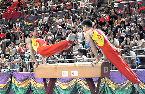 Chinese Olympic championship gymnasts Xiao Qin(L) and Yang Wei perform on the pommel horse in a gym of Hong Kong Saturday during their three-day visit to the city. [Xinhua]