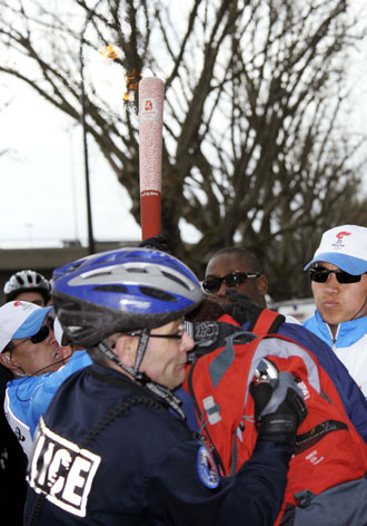 French police stop a Tibet separatist (in red) who tries to grab the Beijing Olympic torch during its relay in Paris, April 7, 2008. Japanese Foreign Minister Masahiko Komura on Tuesday condemned some protesters for violently disrupting torch relay. [Xinhua]