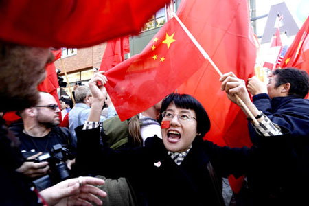 A woman waving a Chinese flag shouts before the beginning of the Olympic Torch relay in San Francisco, California April 9, 2008. The International Olympic Committee has no plans to stop the Beijing Olympic torch relay despite recent disruptions by Tibetan separatists and their supporters, IOC president Jacques Rogge said in Beijing on Thursday. [sohu.com]