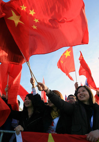 Overseas Chinese wave Chinese national flags during the openning ceremony for the Beijing Olympic torch relay in Canberra, Australia, April 24, 2008. Eighty torch runners will run through the 16-km routes which started from the Reconciliation Place in front of the old parliament house and will end at the Stage 88 in the Commonwealth Park. [Xinhua]