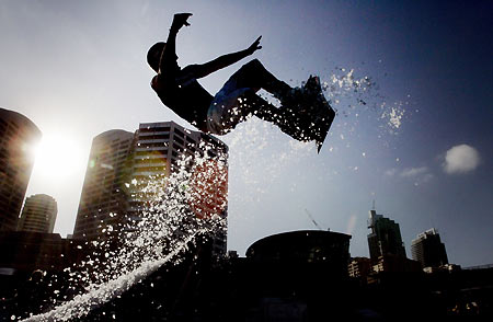 Australian snowboarder Mark Cowley flys off the end of a snow jump in central Sydney March 9, 2006. The promotional event was staged on a ramp covered with man-made snow on a day when the temperature is expected to reach 32 degrees celcius (90 fahrenheit). [Reuters]