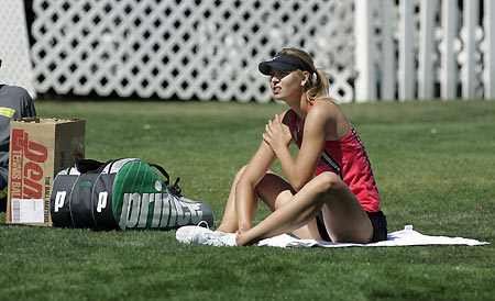 Third seed Maria Sharapova of Russia sits on the grass while stretching after her practice session at the Pacific Life Open in Indian Wells, California March 8, 2006.[Reuters] 