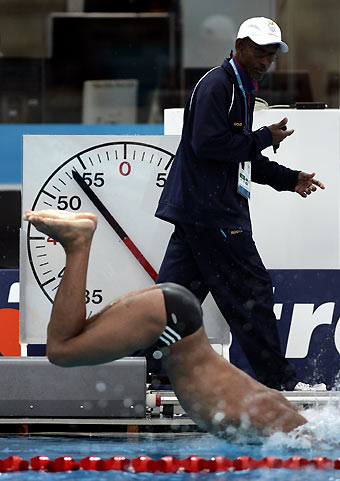 Barbados Commonwealth Games swim team member Andrei Cross dives into the pool as a team coach times him during training in Melbourne March 14, 2006. [Reuters]