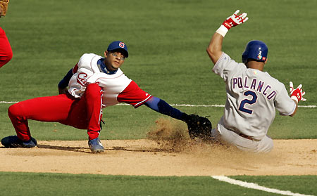 Cuban second baseman Yulieski Gourriel (L) puts the tag on Dominican Republic baserunner Placido Polanco, who was attempting to steal second base, in the fourth inning during their game in the 2006 World Baseball Classic in San Juan, Puerto Rico March 13, 2006. [Reuters]