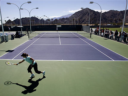 Martina Hingis of Switzerland (foreground) reaches for a backhand as she works out on a practice court at the Pacific Life Open tennis tournament at Indian Wells, California March 13, 2006. [Reuters]