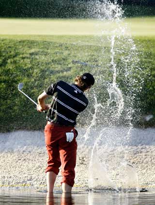 Sergio Garcia of Spain hits from the water on the 17th hole during the third round of the Bay Hill Invitational PGA golf tournament in Orlando, Florida, March 18, 2006. Garcia scored a bogey four on the hole and finished the round eight-under-par for the tournament with a 208 total.