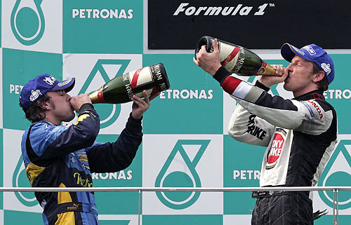 Renault Formula One driver Fernando Alonso (L) of Spain and Honda driver Jenson Button of Britain drink champagne on the podium after the Malaysian F1 Grand Prix at Sepang International Circuit March 19, 2006. Alonso finish second behind teammate Giancarlo Fisichella of Italy, while Button came in third. [Reuters]
