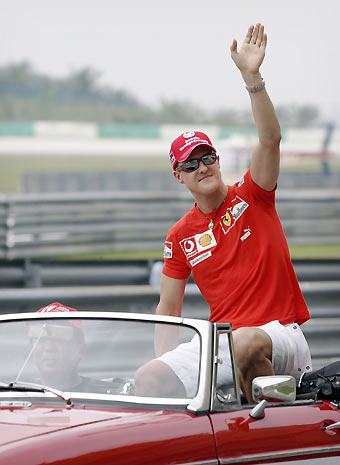 Ferrari Formula One driver Michael Schumacher of Germany waves during the drivers parade before the start of the Malaysian Grand Prix at the Sepang International Circuit outside Kuala Lumpur March 19, 2006. [Reuters]