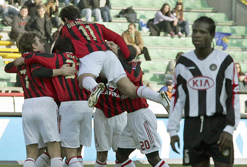 AC Milan's Alberto Gilardino (11) jumps on team mates celebrating his goal as Udinese's Christian Obodo (R) watches during their Italian Serie A soccer match in the northern city of Udine March 19, 2006. Shevchenko struck twice to keep AC Milan in second place in Serie A with a 4-0 demolition of Udinese on Sunday. [Reuters]
