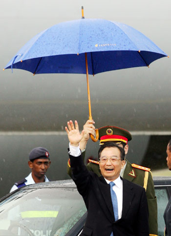 Chinese Premier Wen Jiabao as he waves to a small crowd while preparing to leave Nadi, Fiji April 5, 2006. Wen received a pig and whale's tooth in a traditional Fijian welcome on Wednesday and in return offered a sweeping package of economic aid to Pacific island states that support a one-China policy. Wen said China will grant zero-tariff treatment to those islands, cancel their debt that matured at the end of 2005, provide three billion yuan in preferential loans and make all seven island states with diplomatic ties approved tourist destinations. 