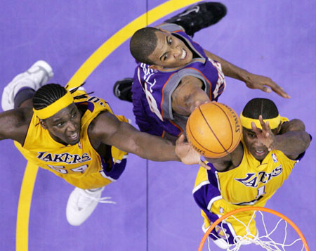 Los Angeles Lakers' Smush Parker (R) and Kwame Brown (L) grab a rebound ahead of Phoenix Suns' Raja Bell during the Lakers' 99-92 win in Game 3 of the NBA Western Conference first round playoff series in Los Angeles, April 28, 2006. 