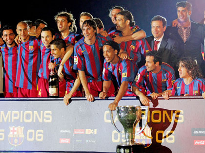 Barcelona's players pose with the championship trophy with Barcelona's president Joan Laporta (back 2nd R) and coach Frank Rijkaard (back R) after their Spanish first division soccer match against Espanyol at the Nou Camp stadium in Barcelona, Spain May 6, 2006. Barcelona won 2-0. 