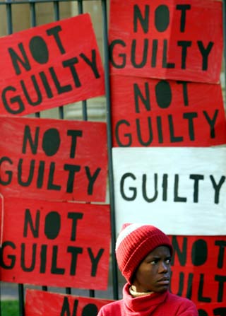 A women's rights activist protests outside the Johannesburg High Court, before former South African Deputy-President Jacob Zuma was acquitted on rape charges, May 8, 2006. A South African judge on Monday acquitted Zuma of raping an HIV-positive family friend, ending a case that opened deep rifts in the ruling African National Congress. [Reuters]