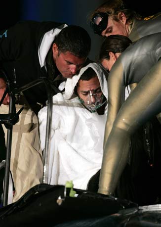 American stuntman David Blaine is given oxygen after his unsuccessful attempt at a record for holding his breath underwater at Lincoln Center in New York May 8, 2006. Blaine lasted seven minutes and eight seconds after spending seven days in the tank.