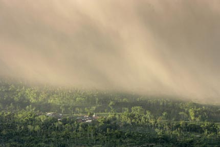 Ash rain cover villages at the slopes of Mount Merapi volcano as seen from Ketep village, near the Indonesian city of Muntilan May 15, 2006. Indonesia raised the alert status of Merapi to the highest level, also known as code red or danger status, on Saturday, although experts said they could not predict when it would erupt. 