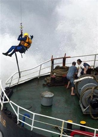 A helicopter lifts a crew members off an oil tanker which ran aground, May 17, 2006, in Kaoshiung, 350 kilometers (217 miles) south west of Taipei. The tanker ran aground in stormy seas swollen by typhoon Chanchu. The typhoon, the strongest ever reported in the South China Sea in May, was expected to pass between Hong Kong and Taiwan on Wednesday and slam into Guangdong province on Thursday morning. [AP Photo]