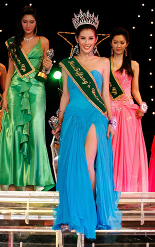 Ratravee Jirapraphakul (C), 22, smiles after winning the Miss Tiffany's Universe transvestite contest in the Thai resort city of Pattaya, about 150 km (93 miles) southeast of Bangkok May 20, 2006. Thirty contestants entered the contest this year, which aims to promote a positive transvestite image internationally. [Reuters]