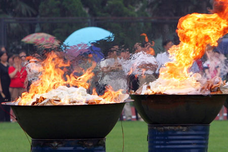 A military policeman lights up drugs at a university campus, three days before June 26, the International Day against Drug Abuse and Illicit Drug Trafficking in Shanghai June 23, 2006.