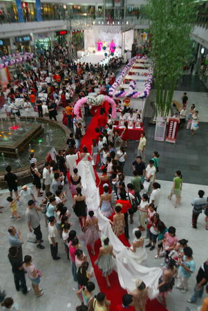 A 9.9-meter-long wedding dress is shown during the International Wedding Dress which kicked off in Dalian, northeast China's Liaoning Province Saturday. [New Business]