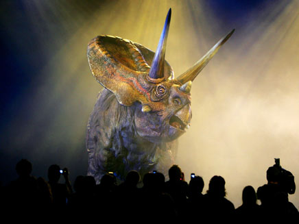 Members of the media watch a life-sized, walking model of a Torosaurus dinosaur as it performs during the world premiere of 'Walking With Dinosaurs - The Live Experience' in Sydney August 1, 2006. The A$12 million (US$9 million) show, based on the BBC television series 'Walking With Dinosaurs', will consist of 15 life-sized animatronic dinosaurs performing on stage. It will open to the public in January 2007, and will travel around the world later that year. [Reuters] 