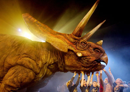 Members of the media watch a life-sized, walking model of a Torosaurus dinosaur as it performs during the world premiere of 'Walking With Dinosaurs - The Live Experience' in Sydney August 1, 2006. The A$12 million (US$9 million) show, based on the BBC television series 'Walking With Dinosaurs', will consist of 15 life-sized animatronic dinosaurs performing on stage. It will open to the public in January 2007, and will travel around the world later that year. [Reuters] 