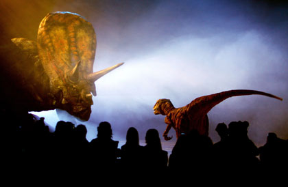 Members of the media watch a life-sized, walking model of a Torosaurus dinosaur as it performs during the world premiere of 'Walking With Dinosaurs - The Live Experience' in Sydney August 1, 2006. The A$12 million (US$9 million) show, based on the BBC television series 'Walking With Dinosaurs', will consist of 15 life-sized animatronic dinosaurs performing on stage. It will open to the public in January 2007, and will travel around the world later that year. [Reuters] 