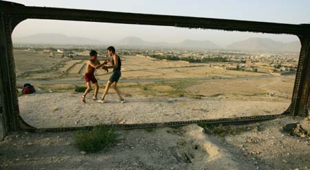 A young Afghan wrestler exercises on a hilltop in Kabul August 3, 2006.[Reuters]
