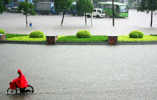 A cyclist rides on a flooded street after Typhoon Prapiroon in Foshan, South China's Guangdong Province August 3 2006.