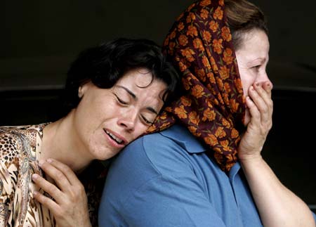 Women mourn after a rocket hit a house in the northern Israeli town of Deir al-Assad August 10, 2006. A rocket fired by Lebanese Hizbollah guerrillas hit a house in Deir al-Assad on Thursday, killing two people, including a toddler, emergency services said.