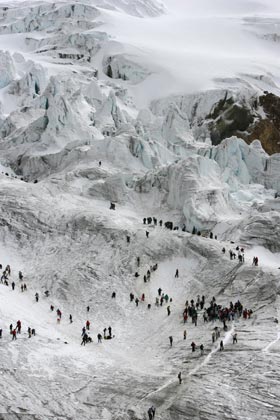 People walk along the slopes of the Cayambe volcano during the Ruta del Hielo (Ice Route) competition, 45 kilometres north of Quito, August 27, 2006. Participants carry blocks of glacial ice on their backs down the 5,790 meter-high volcano to the town. The annual competition evolved from the tradition of ice harvesting to make ice cream, a practice that died with the advent of electric ice-makers. 