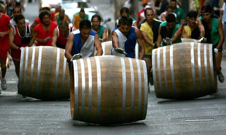 Participants compete during a wine barrel race in Montepulciano, near Siena, central Italy, September 3, 2006. The race, known as the Il Bravio delle Botti, is the highlight of a 10-day holiday dating back to the 14th century to celebrate Montepulciano's patron Saint John the Baptist, with costumed ceremonies, dance parties, street theatre performances and lavish parties served on the squares. Picture taken September 3, 2006. 