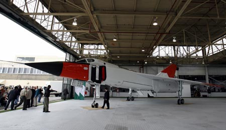 Members of the media puruse a life-size model of the Avro Arrow fighter unveiled during a media preview at the Toronto Aerospace Museum, September 28, 2006. The Toronto-built Arrow was the world's most advanced new jet fighter design when the Canadian government killed the program for political and economic reasons in 1959. 