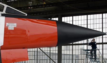 A member of the media photographs a life-size model of the Avro Arrow fighter unveiled during a media preview at the Toronto Aerospace Museum, September 28, 2006. The Toronto-built Arrow was the world's most advanced new jet fighter design when the Canadian government killed the program for political and economic reasons in 1959.