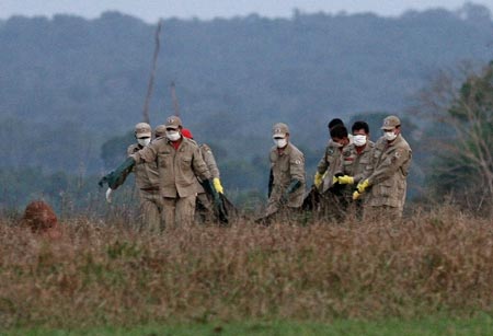 Rescue workers carry the bagged remains of victims of Gol airlines flight 1907 that crashed in the Brazilian Amazon jungle, after the remains were flown from the crash site to the Jarina ranch near the Jarina Indian reserve October 3, 2006. Searchers have found about 50 bodies scattered around the site of Brazil's worst airplane crash and were keeping wild animals away from the corpses, air force officials said on Tuesday.