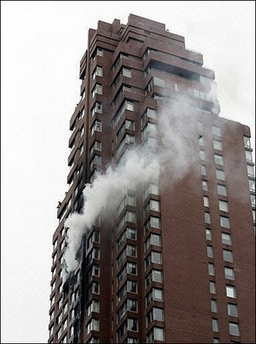 Smoke billows out the windows of a high-rise building after a small aircraft crashed into it in New York City October 11, 2006. 