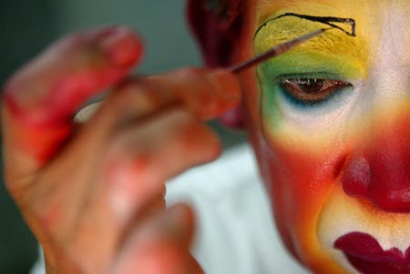 A clown paints his face as preparation for his performance at an international clown convention in Mexico City October 18, 2006. 
