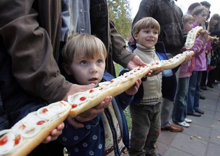 Children hold baguettes with salo (pig's fat) forming a 43 metres-long (141 feet) sandwich during a salo festival in Lutsk some 400 km (249 miles) northwest of Kiev October 22, 2006. 