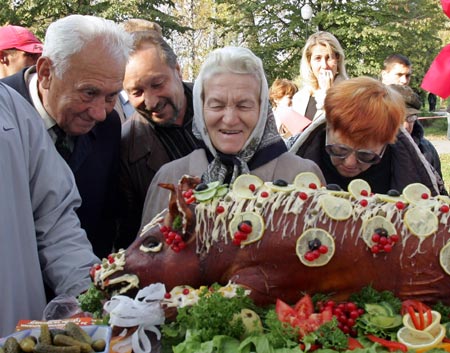 People look at a stuffed piglet during the first salo-lovers (pig's fat lovers) championship in Lutsk, about 400km (249 miles) north-west of Kiev October 22, 2006. 
