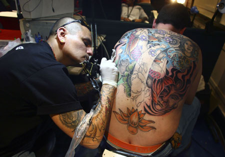 A man has his back tattooed during the International Tattoo Convention in