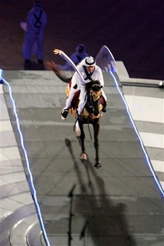 A horseman rides his charge to the top of the stands to light the Asian Games flame during the Opening Ceremony of the 15th Asian Games in Doha, Qatar, Friday Dec. 1, 2006. (AP