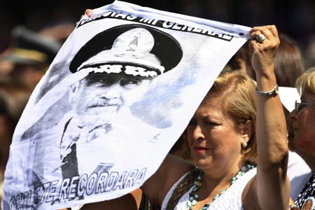 A supporter of former Chilean dictator Augusto Pinochet holds up a poster with his portrait and the words 