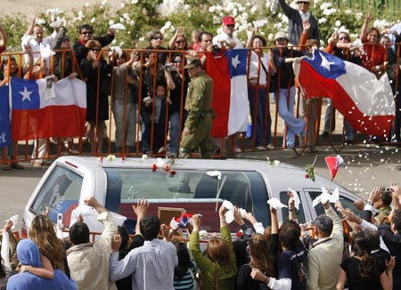 Supporters of former Chilean dictator Augusto Pinochet throw flower petals as his coffin is driven past on its way to the crematorium in the city of Concon on the Pacific Coast, December 12, 2006. 