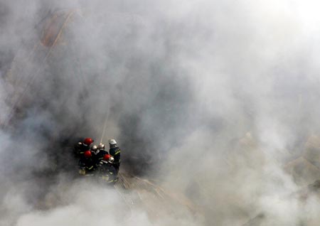 Firemen extinguish a fire at a storeroom inside an electronic company in Xi'an, northwest China's Shaanxi province December 20, 2006. The fire hit the storeroom on Wednesday and destroyed electric equipments which have an estimated value of 10,000,000 RMB ($1,279,000), but no casualty was reported, according to local media. Picture taken December 20, 2006. 