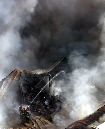 Firemen extinguish a fire at a storeroom inside an electronic company in Xi'an, northwest China's Shaanxi province December 20, 2006. The fire hit the storeroom on Wednesday and destroyed electric equipments which have an estimated value of 10,000,000 RMB ($1,279,000), but no casualty was reported, according to local media. Picture taken December 20, 2006. 