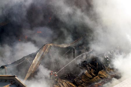 Firemen extinguish a fire at a storeroom inside an electronic company in Xi'an, northwest China's Shaanxi province December 20, 2006. The fire hit the storeroom on Wednesday and destroyed electric equipments which have an estimated value of 10,000,000 RMB ($1,279,000), but no casualty was reported, according to local media. Picture taken December 20, 2006. 