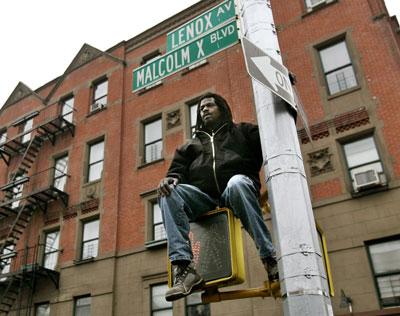 A man watches from a traffic light as a horse-drawn carriage carries the coffin of singer James Brown to the legendary Apollo Theater in Harlem, where Brown made his debut, in New York December 28, 2006. The legendary soul singer died of heart failure from pneumonia on Christmas Day. [Reuters]