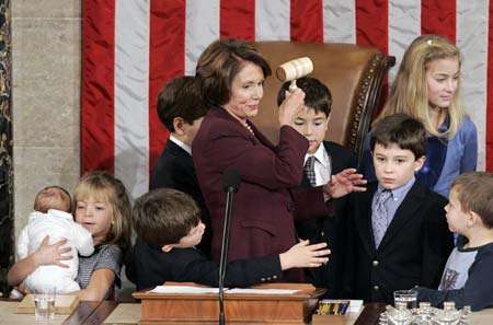 U.S. Speaker of the House Nancy Pelosi holds up the gavel with her grandchildren and the children and grandchildren of other members of Congress after being elected the first ever female Speaker of the House on the first day of the 110th Congress in Washington January 4, 2007. 